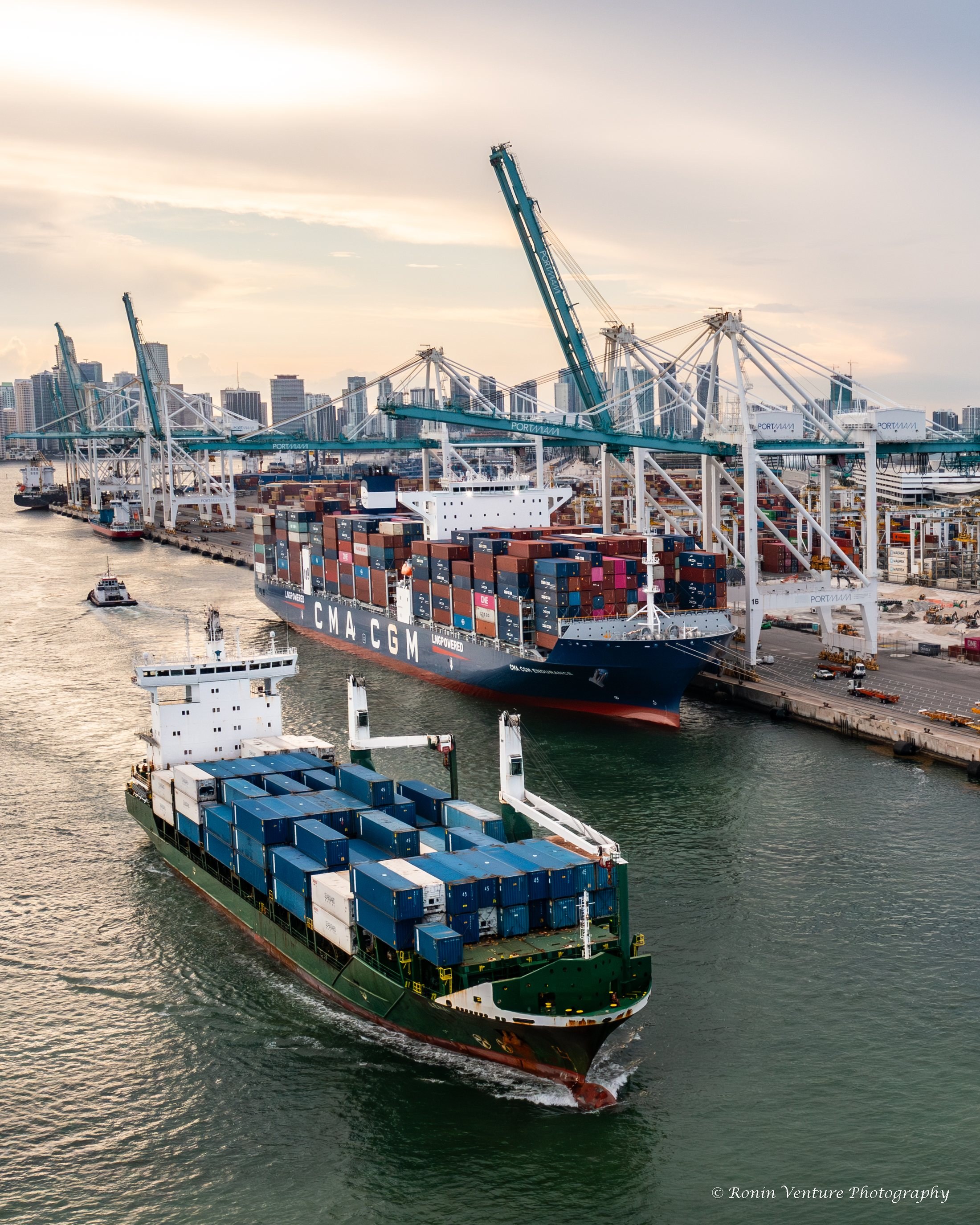Aerial view of PortMiami with cargo cranes, containers, a vessel, and the Miami skyline
